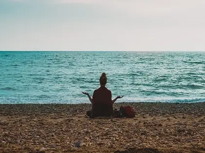 woman yoga meditating sitting beach